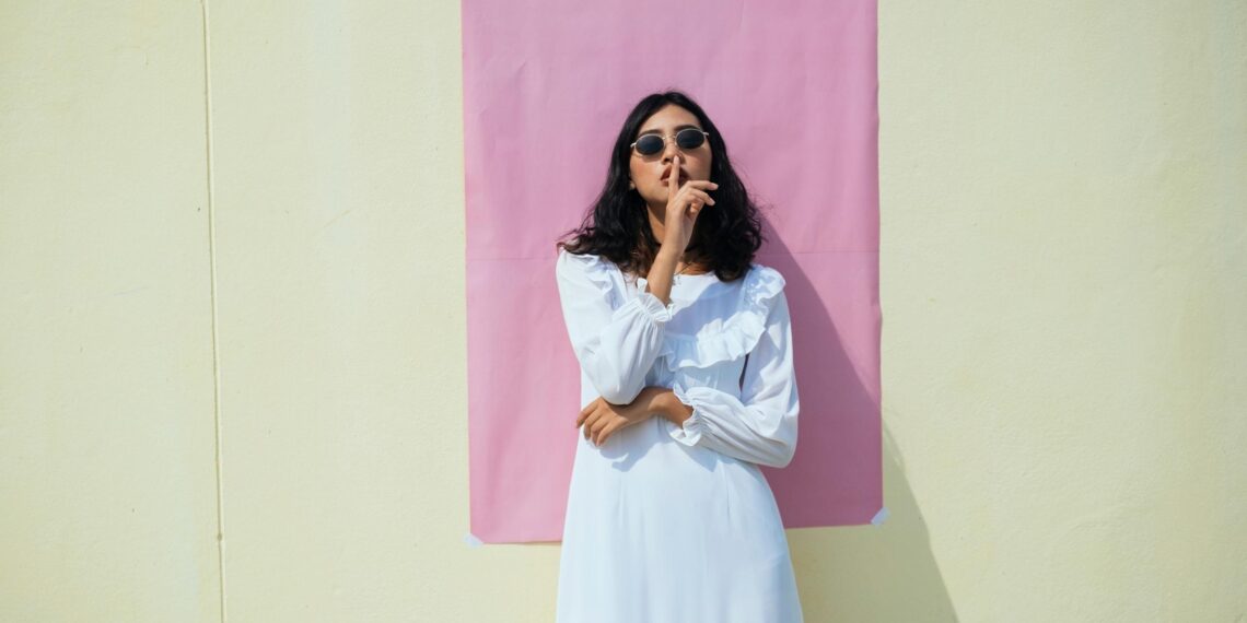 woman standing in front of building doing a shush