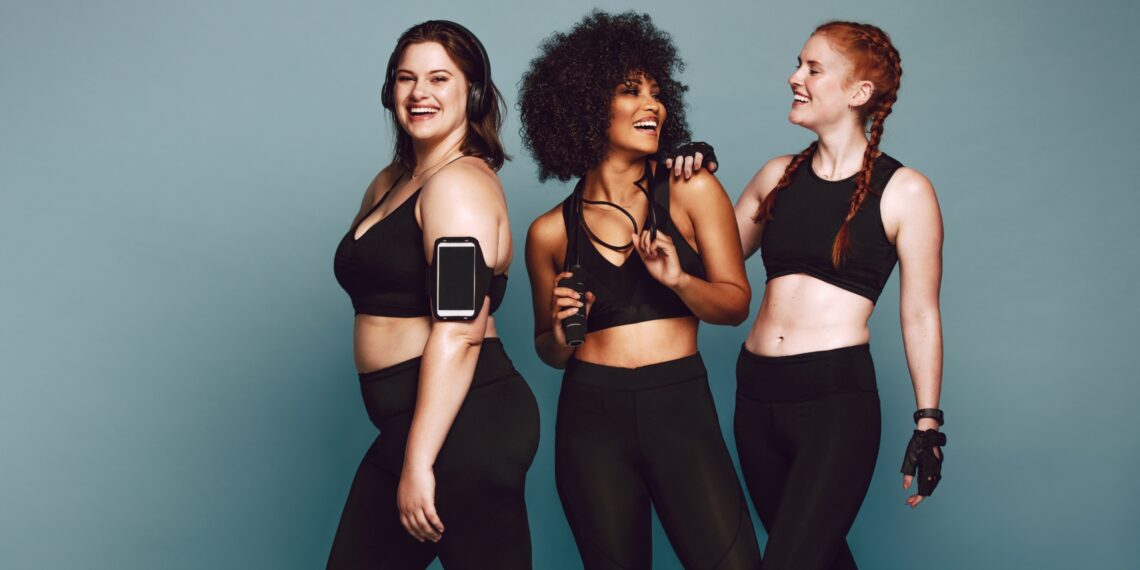 three women in workout clothes and gear smiling
