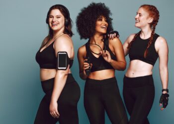 three women in workout clothes and gear smiling