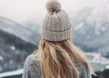 back of woman's head in a beanie looking at mountains